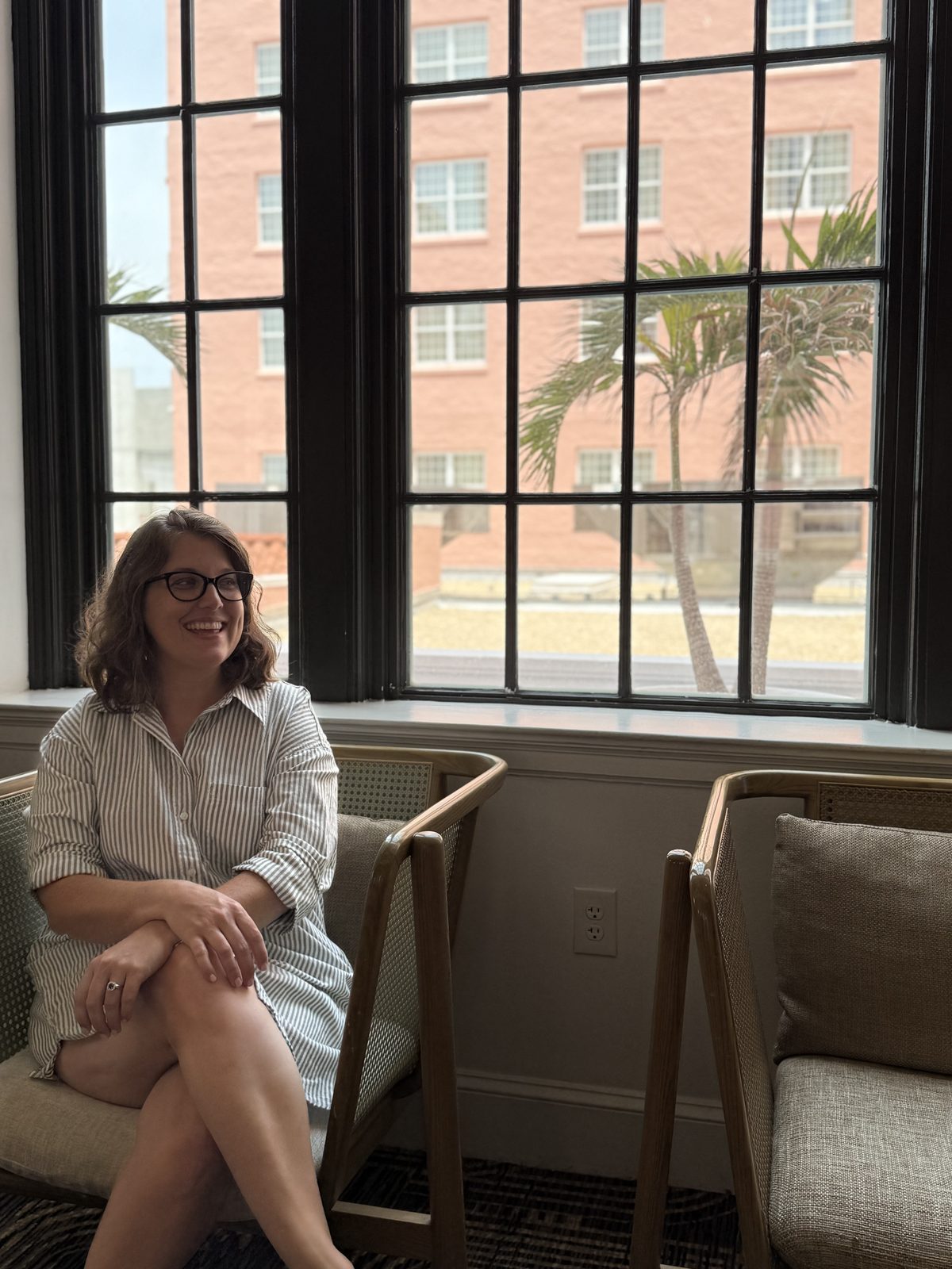 Kate seated by the tall windows